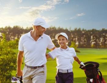father and son walking on the golf course