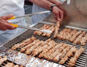 Closeup of a man grilling kebabs at a street festival