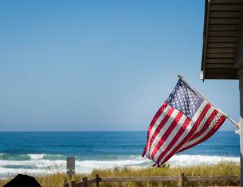 A flag flying above an oceanfront vacation home