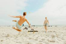 Friends playing ball on the beach
