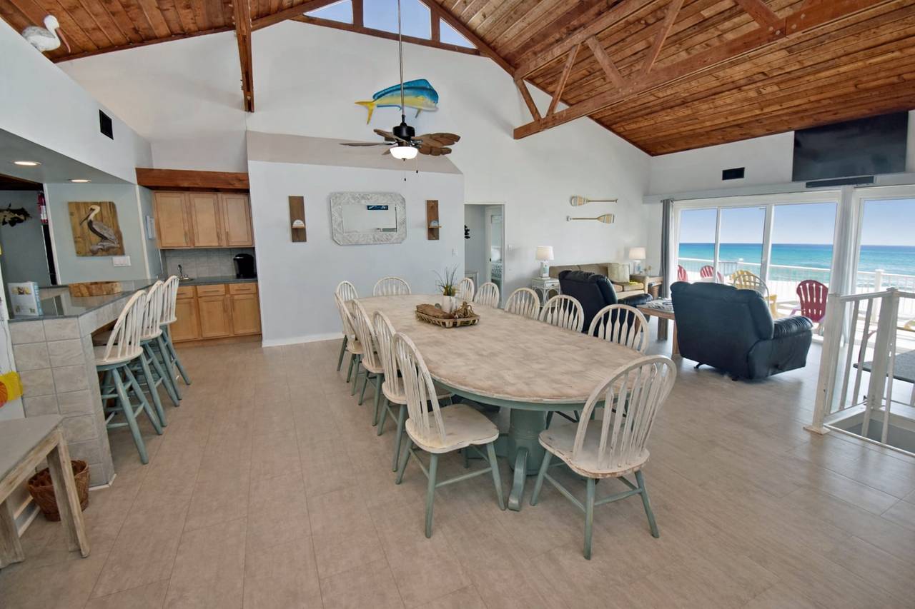 Vacation rental interior with large dining table and ocean views in background