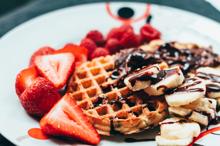 A plate of waffles and strawberries