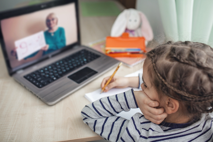 child remote learning at the beach