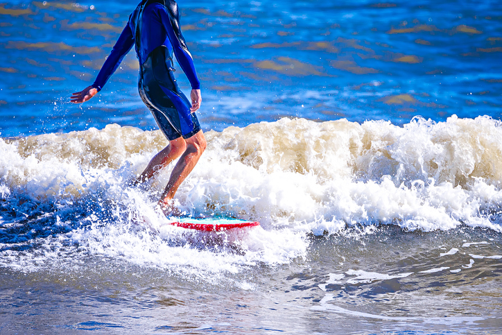 A boy surfs along the Grand Strand