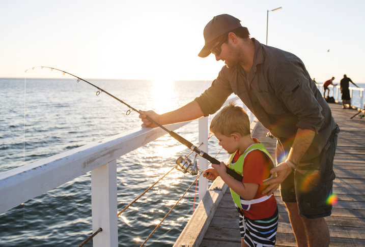 A father and son fishing on a pier