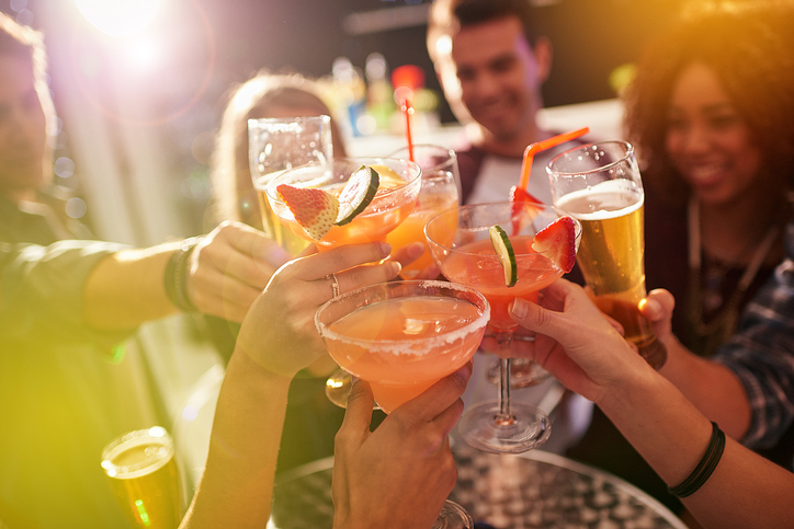 A group of friends cheers a round of drinks