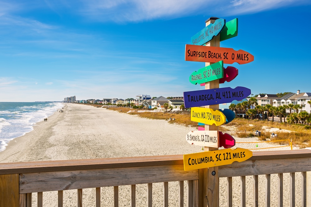 Surfside beach pier with sand and shoreline in background